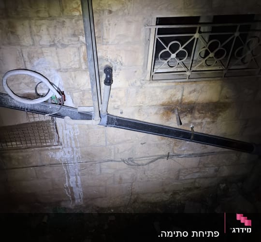 צינורות פלסטיק מחוברים לקיר אבן עם חיבורים